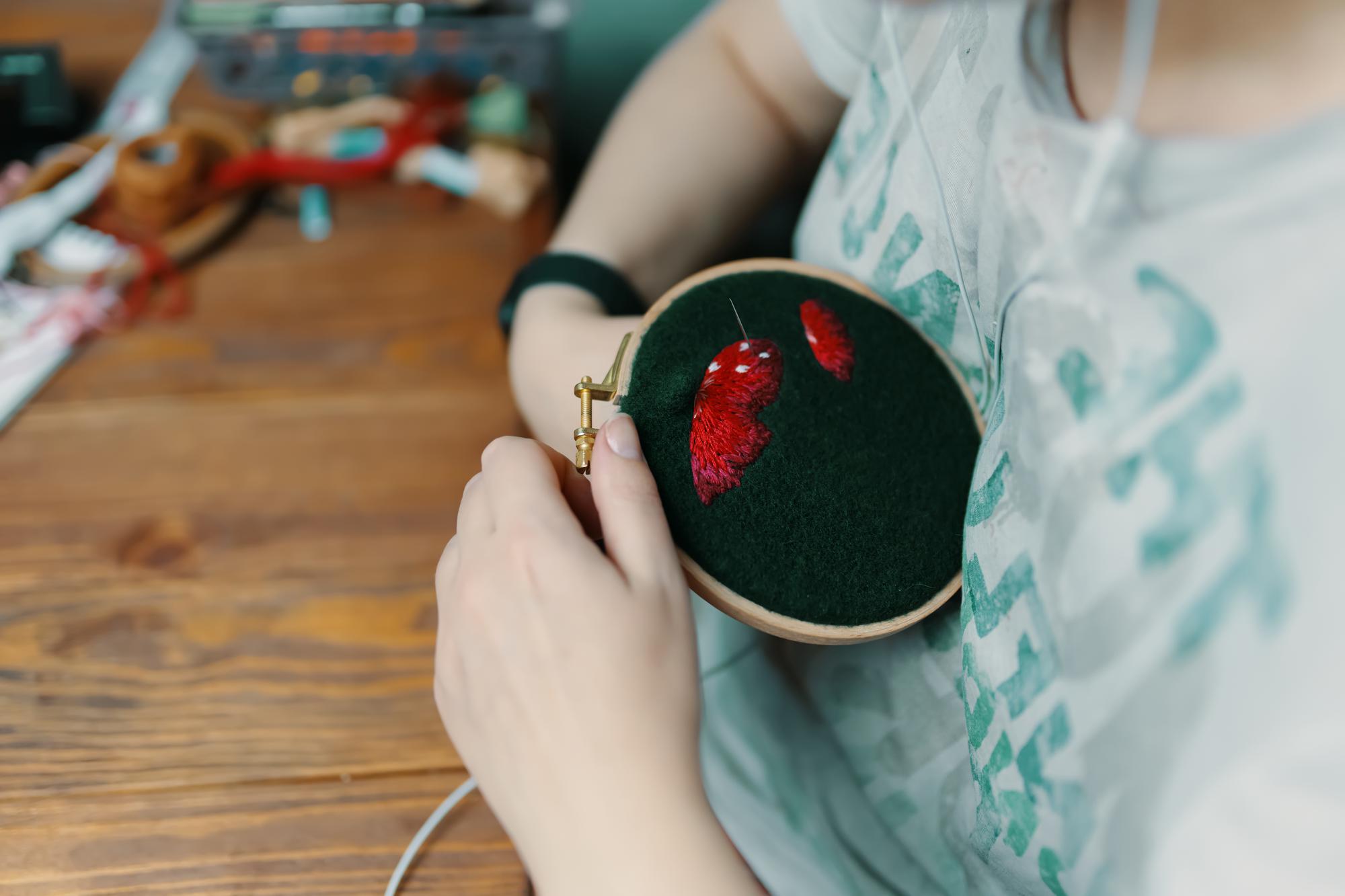 Craftsperson holding embroidered patch